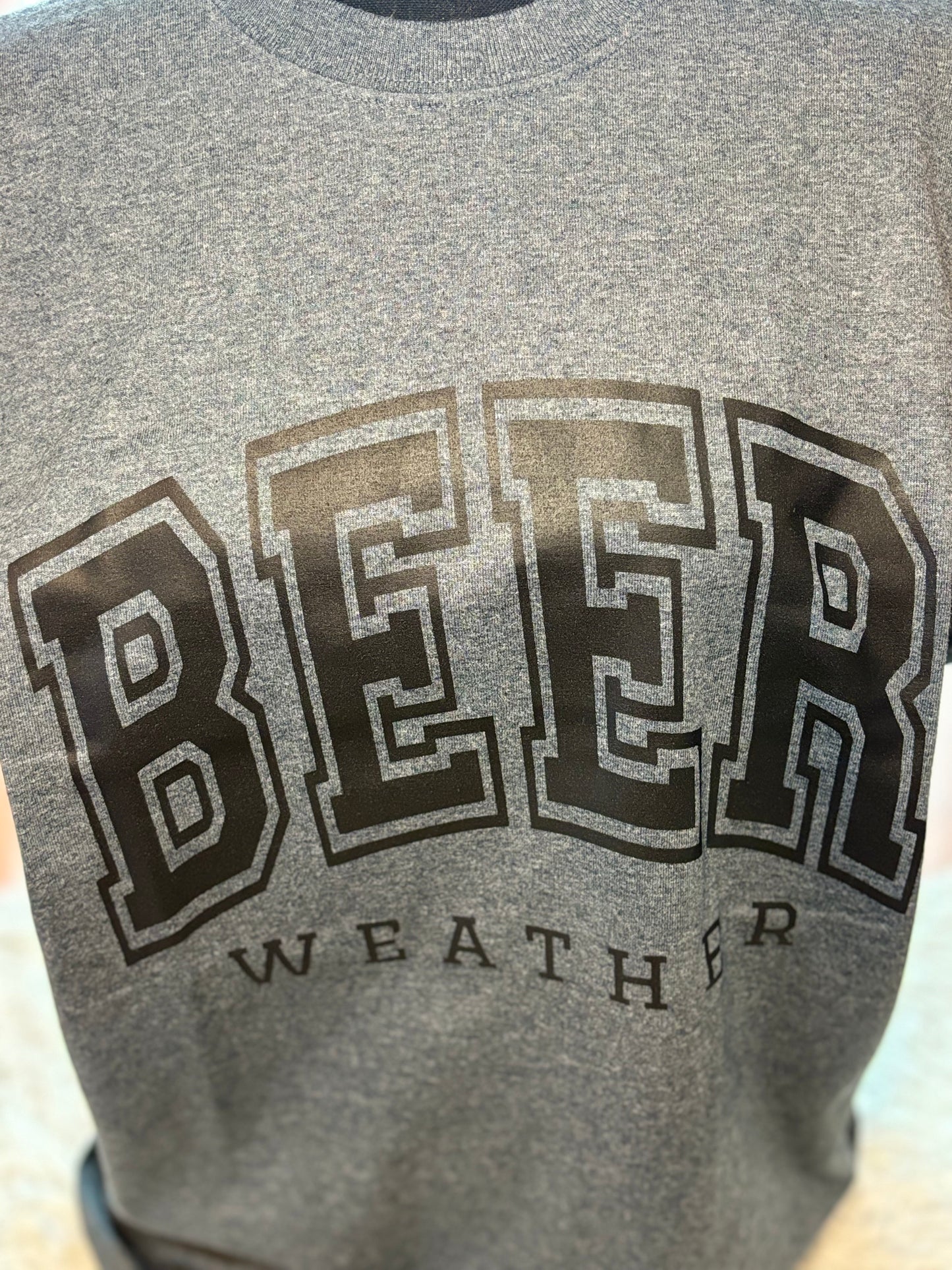 Dark heather heat press t-shirt with 'BEER WEATHER' text in black
