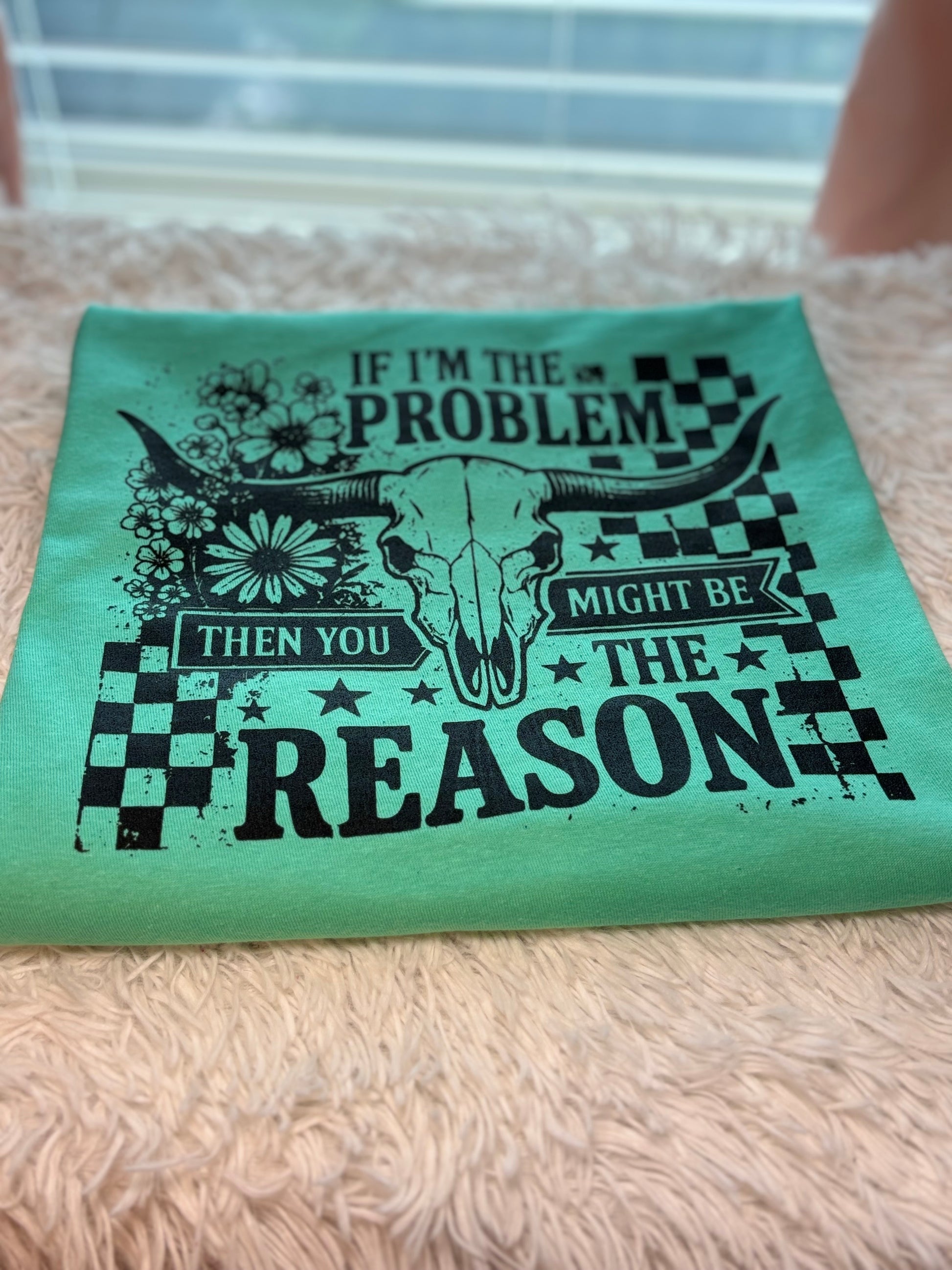 Mint heat press t-shirt with bull skull design and text "If I'm The Problem Then You Might Be The Reason" on a checkered background