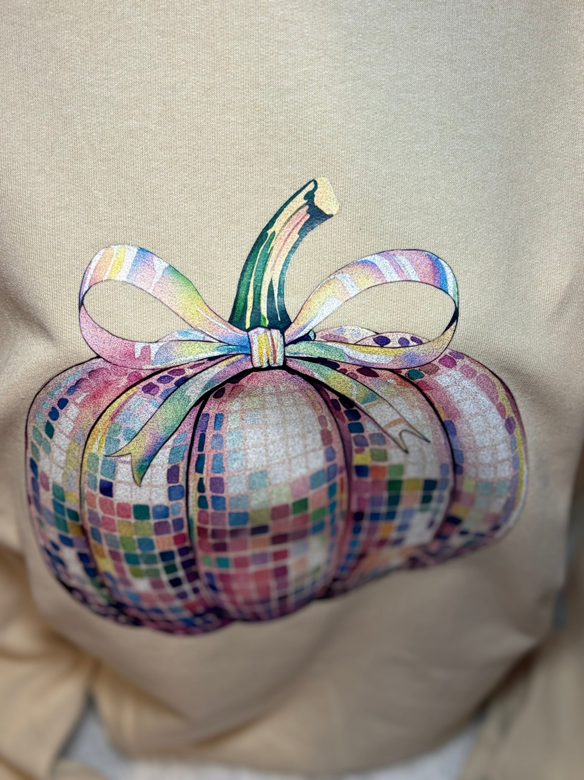 Heat pressed beige sweatshirt with a glitter disco pumpkin design 