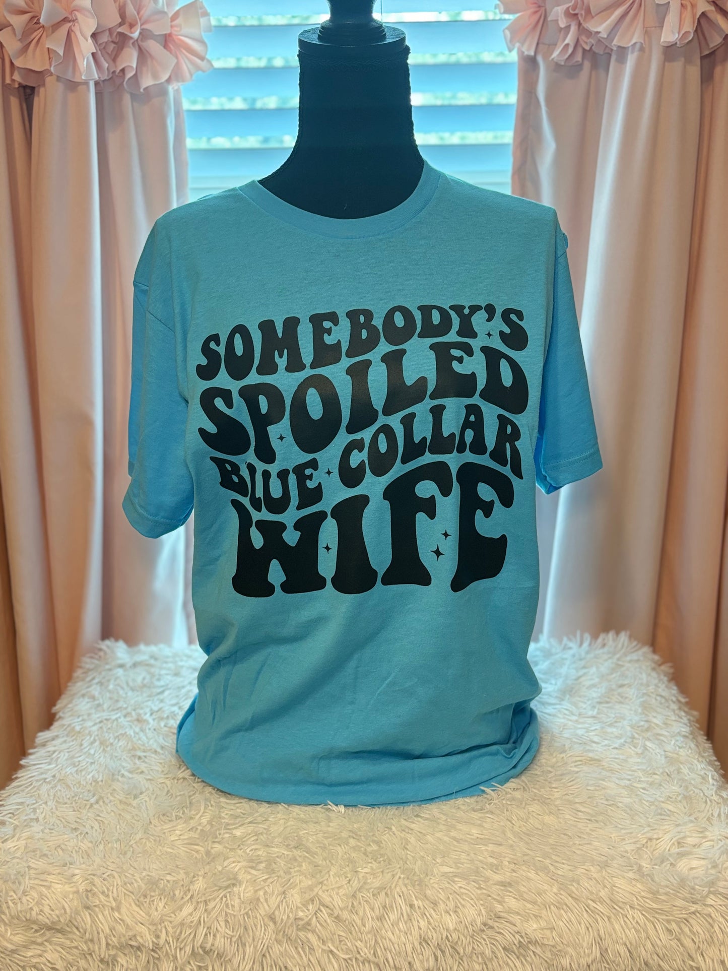 Aqua heat press t-shirt with text 'Somebody's Spoiled Blue Collar Wife' in black 