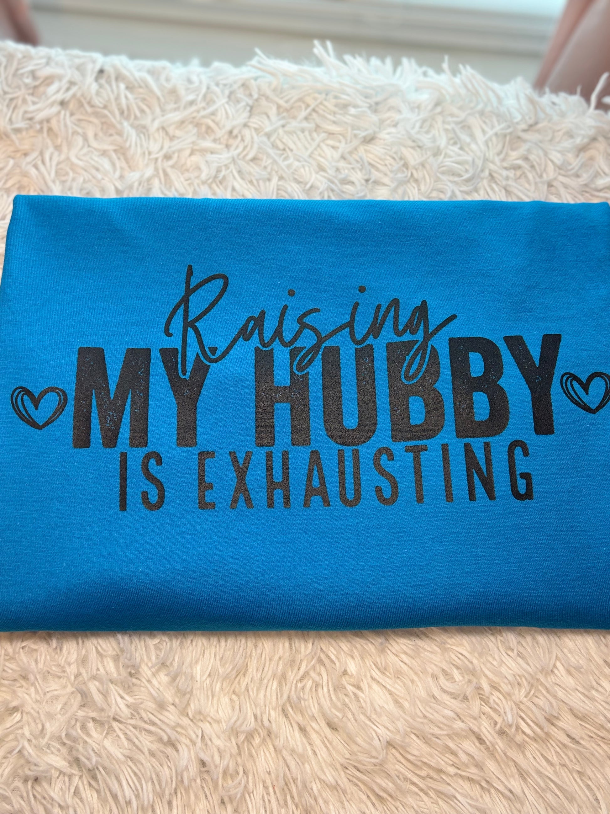 Turquoise heat press t-shirt with text 'Raising MY HUBBY IS EXHAUSTING' in black