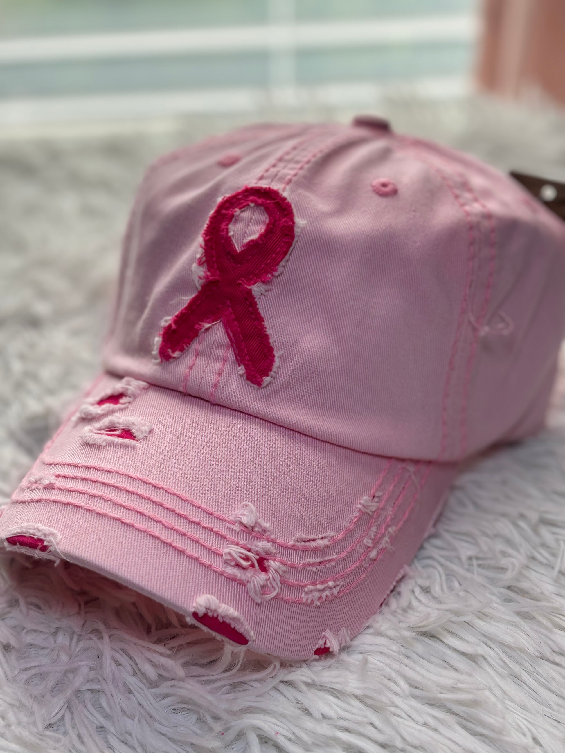 Pink baseball cap with a breast cancer awareness ribbon