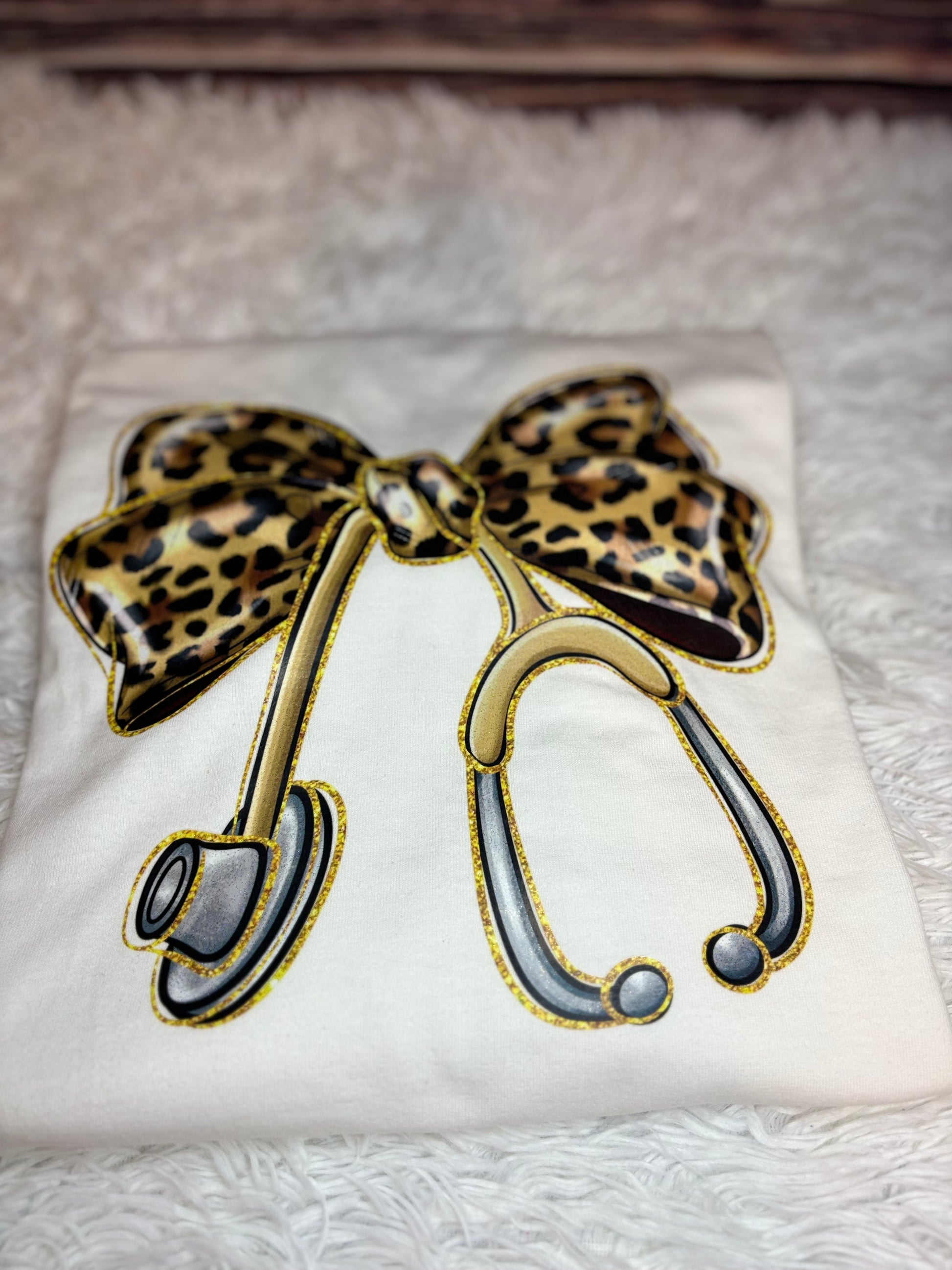 White long sleeve heat pressed t-shirt with a large leopard print bow nurse stethoscope design 