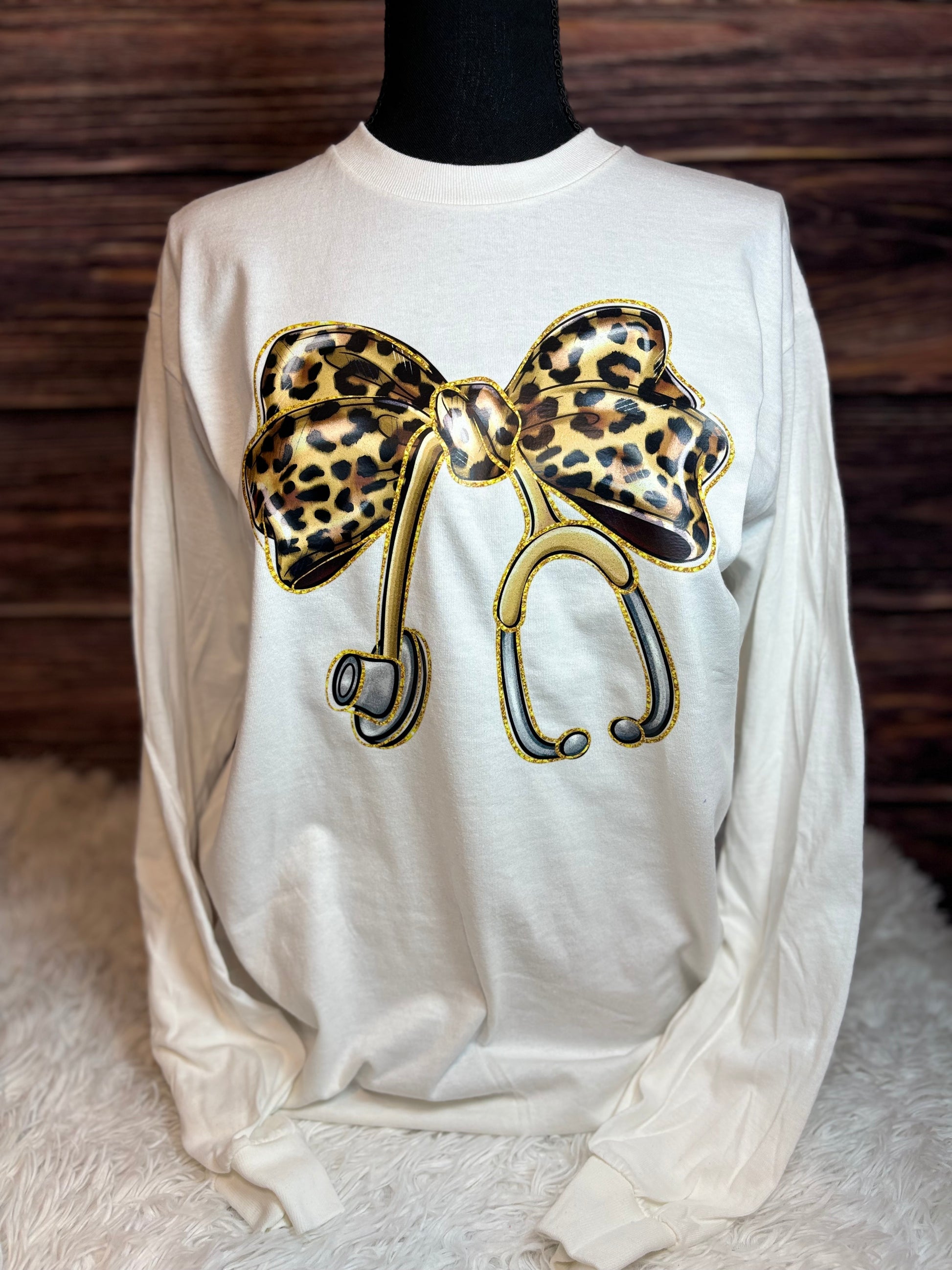 White long sleeve heat pressed t-shirt with a large leopard print bow nurse stethoscope design 