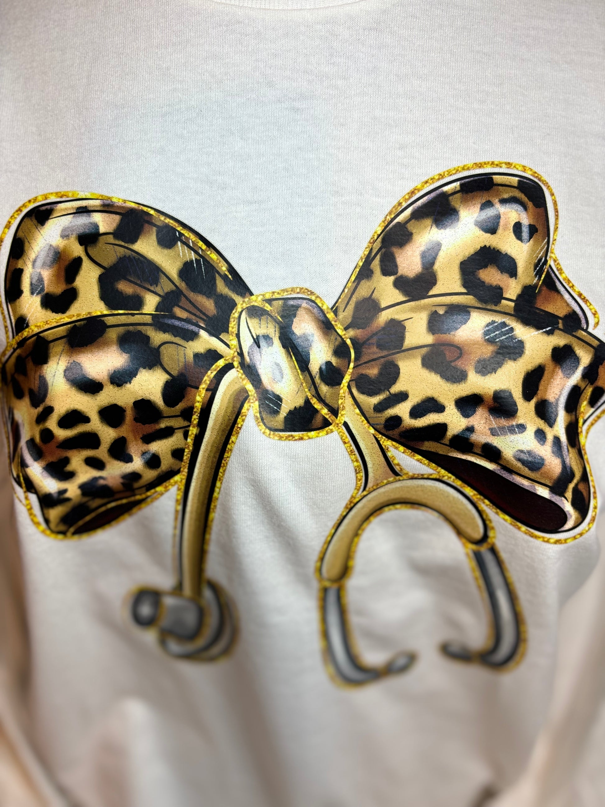 White long sleeve heat pressed t-shirt with a large leopard print bow nurse stethoscope design 