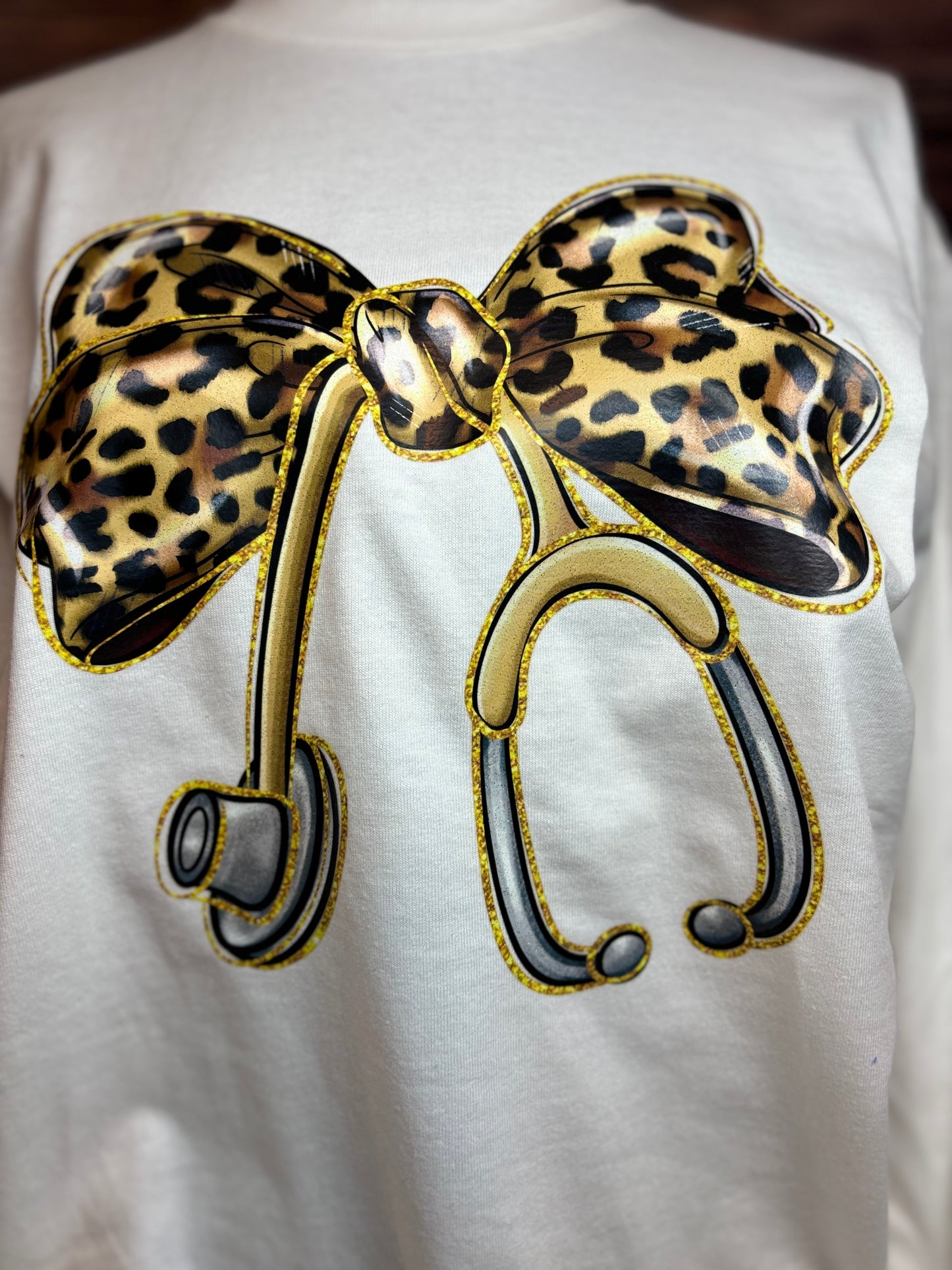 White long sleeve heat pressed t-shirt with a large leopard print bow nurse stethoscope design 